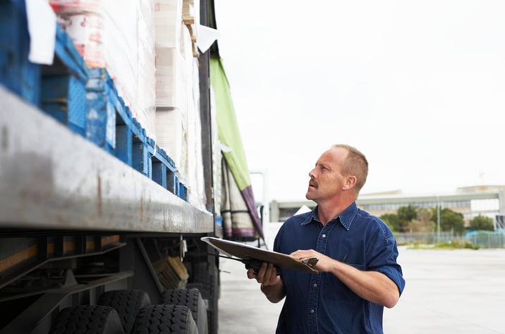 A trucker performing a vehicle inspection on his truck