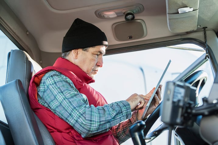 Trucker reads on his tablet before starting his day