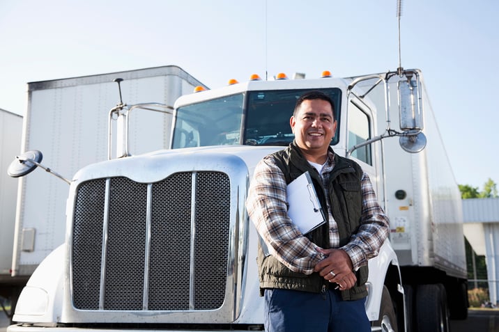 Truck driver stands in front of his truck