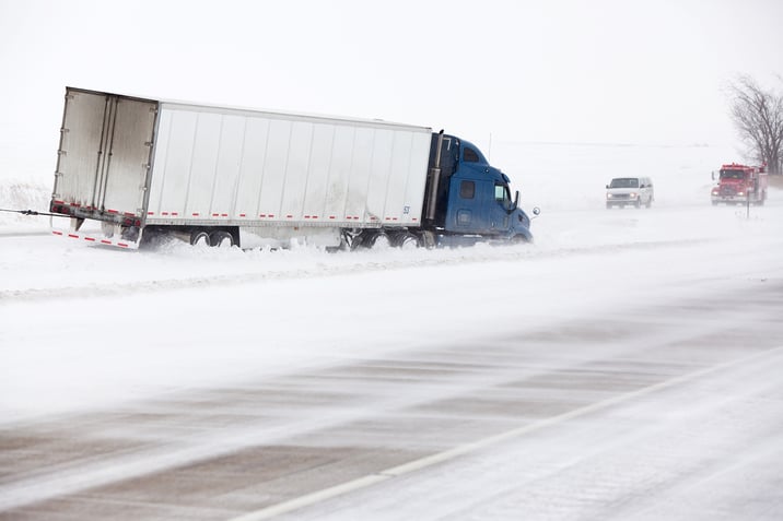 Truck sits in the middle of a snow covered ditch