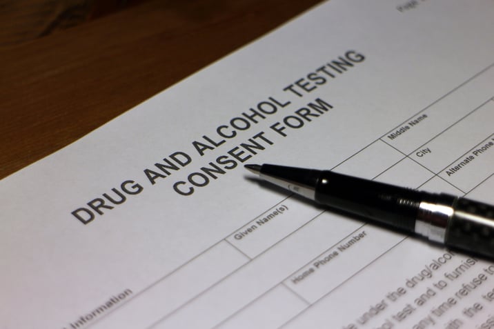 Up close view of drug and alcohol employee testing consent form with pen laying on top. 