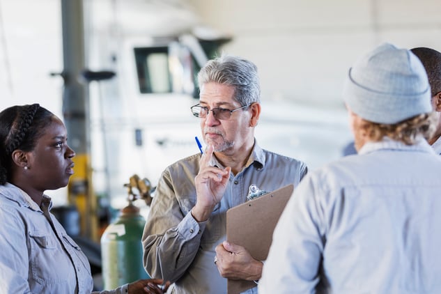 A meeting between four employees in a repair shop