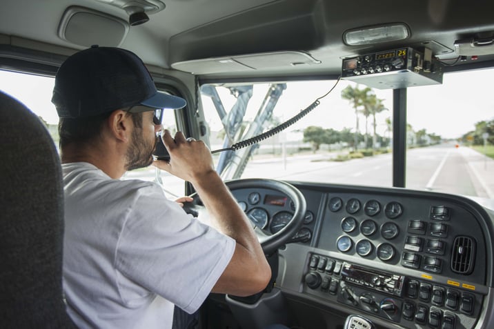 Truck driver talking on CB radio while on the road.