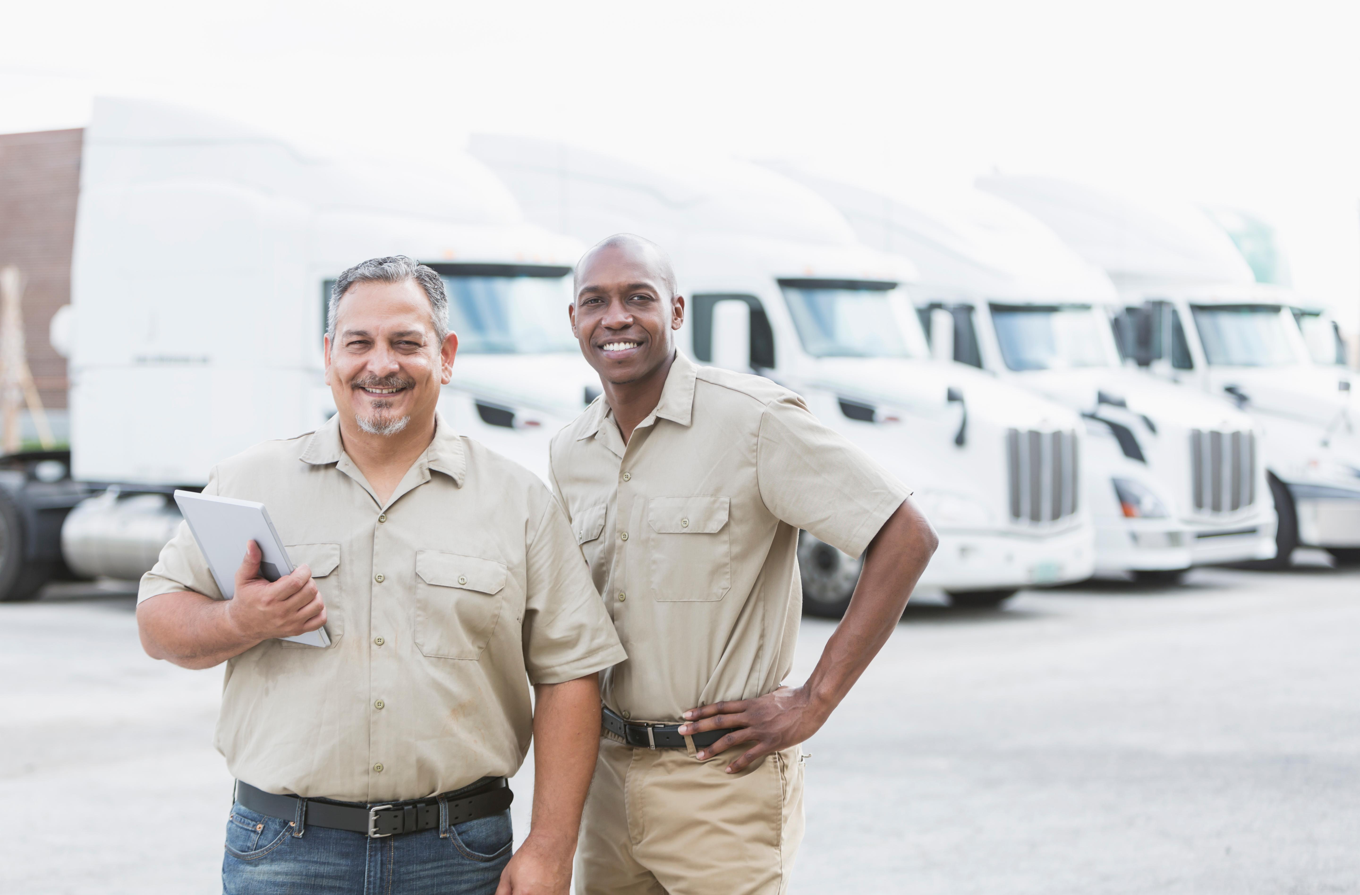 Men standing by semi trucks 