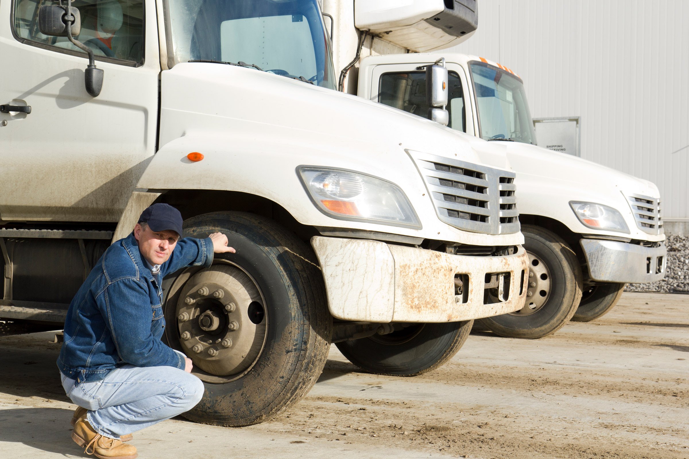 Truck-driver-inspecting-tires 