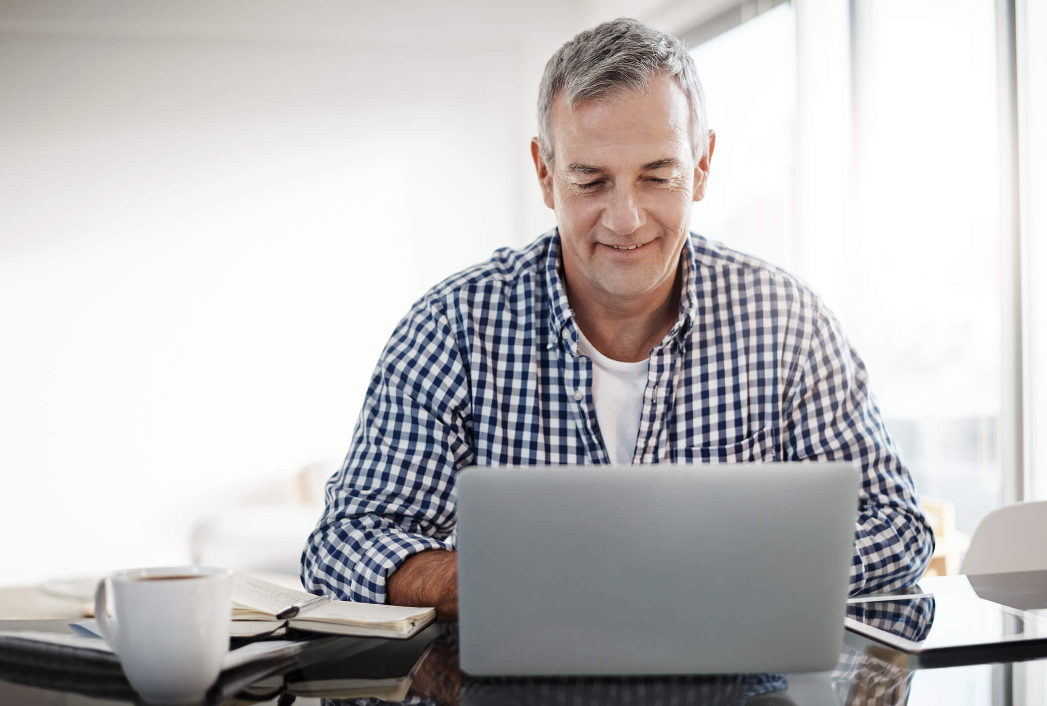 Shot of a mature man working on a laptop at home