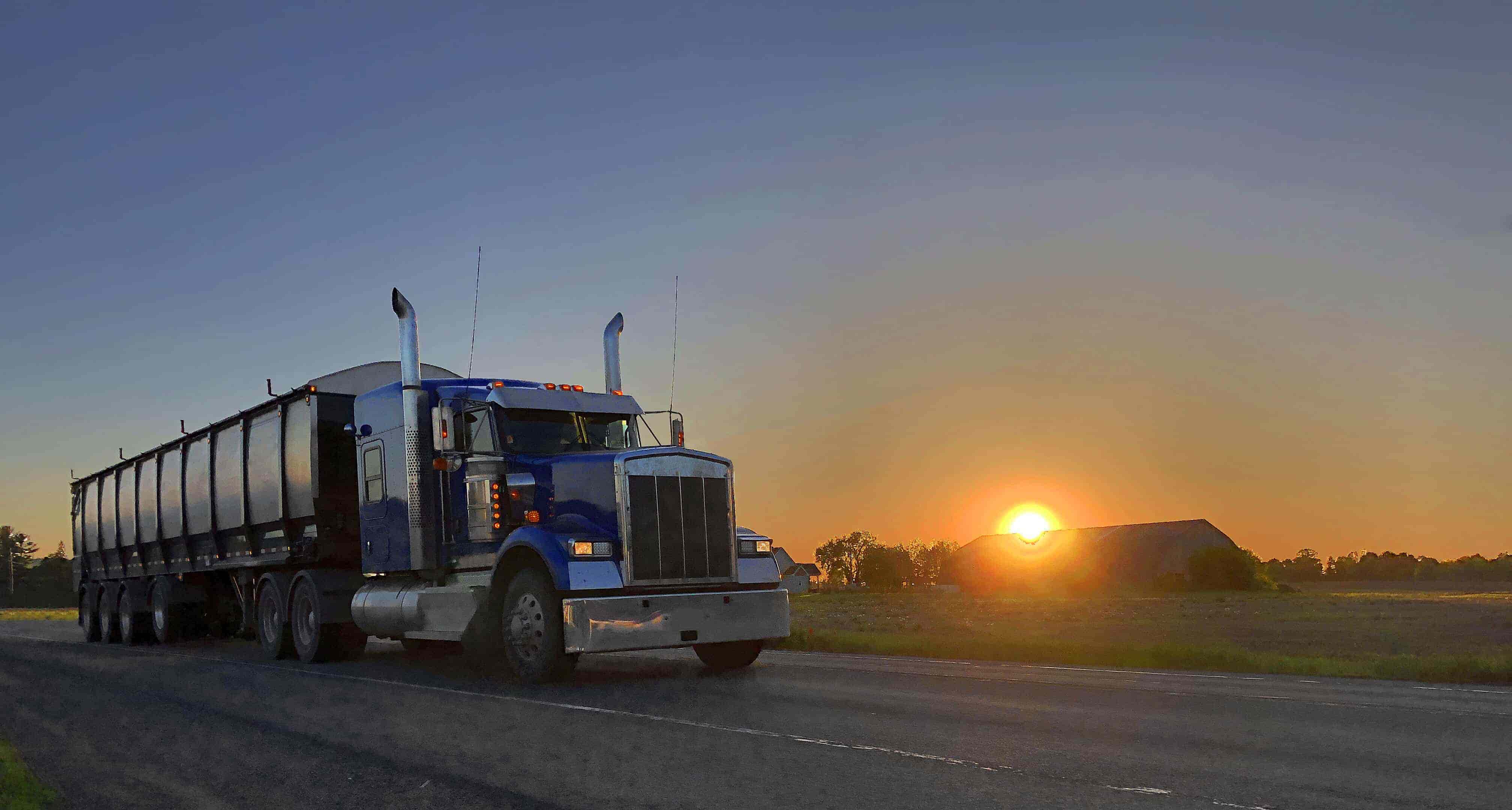 Semi-Truck Leaving a Farm in the Sunrise