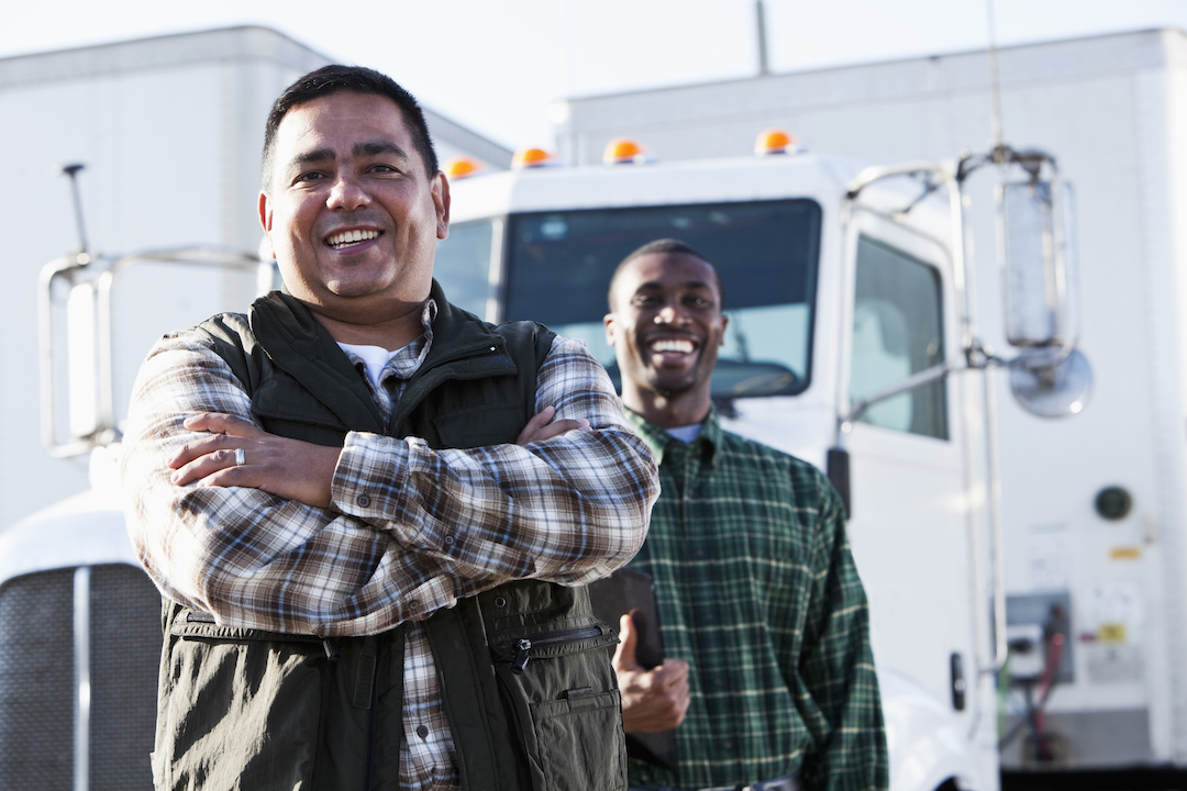 truck drivers smiling in front of semi truck