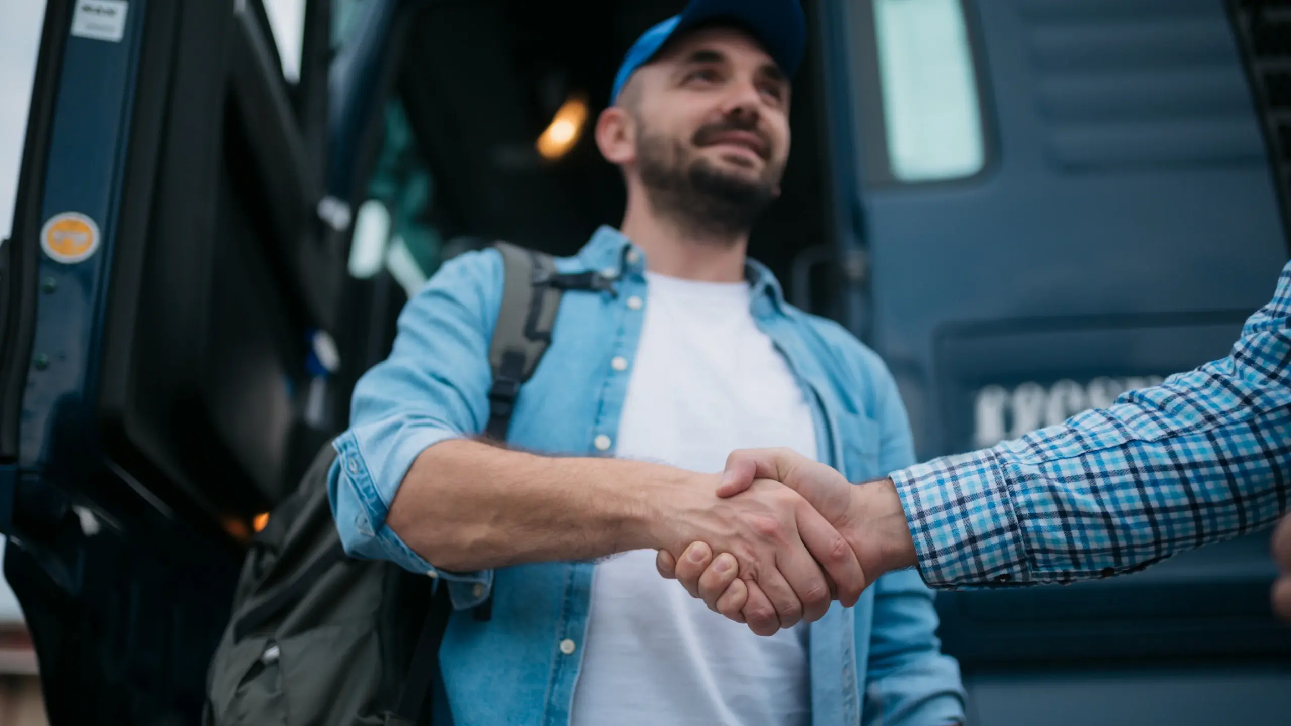 Two truck drivers shake hands before a drive.