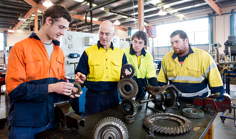group of shop workers examining parts