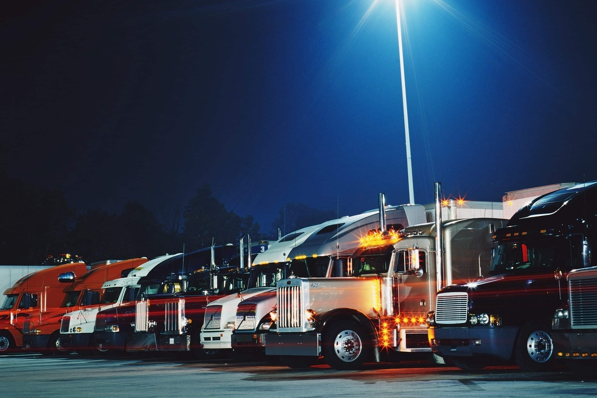fleet of trucks parked at night 